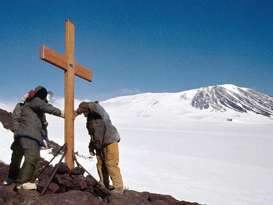 Two people erecting a wooden memorial cross on the lower slopes of Mount Erebus on 20 December 1979, three weeks after the crash.